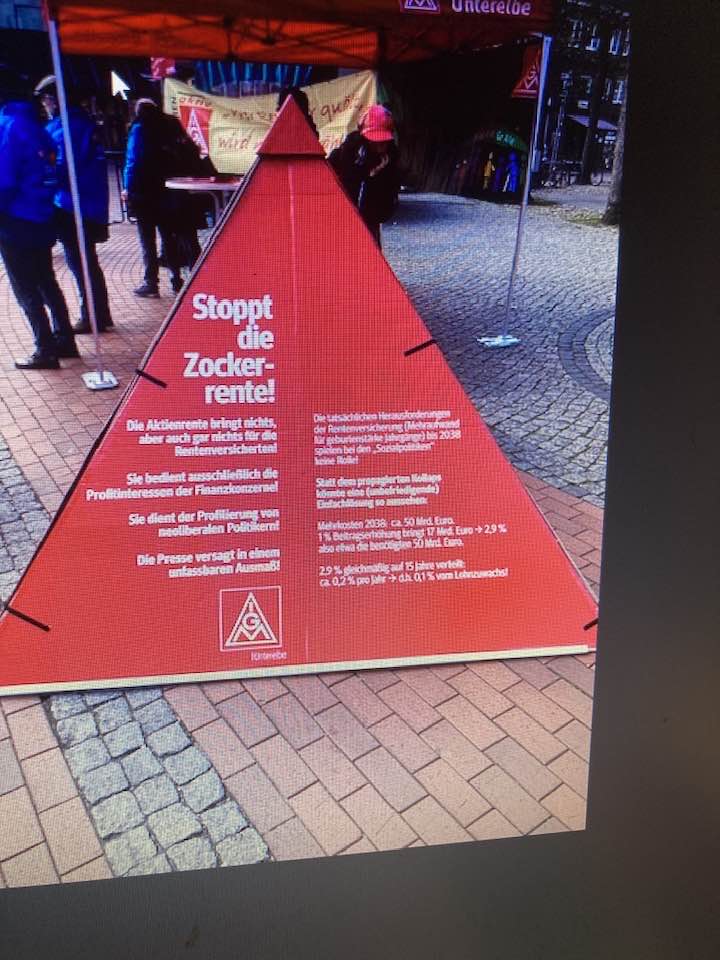 Auf Pflstersteinen steht eine rote Pyramide der IG-Metall mit Überschrift Stopptdie Zocker-Rente.